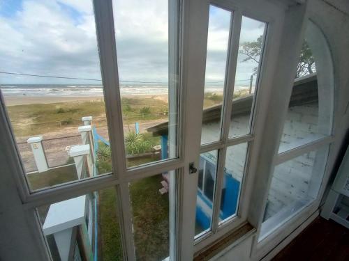 尚格里拉Casa beiramar, solar, barulho do mar, pé na areia!的享有海滩景致的开放式窗户