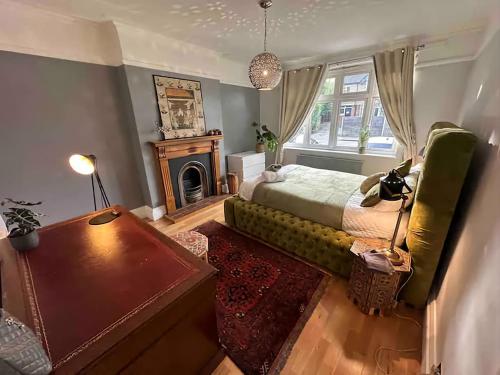 沃特福德The Gemstone Manor的一间卧室配有一张床、一张桌子和一个壁炉