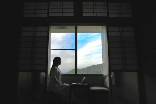 云仙市H,U,B Unzen - Vacation STAY 74185v的坐在窗前的手提电脑的女人