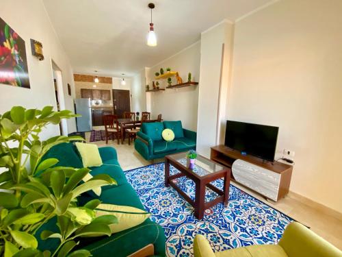 赫尔格达Charbel apartments的客厅配有蓝色的沙发和电视