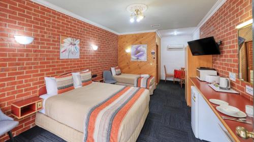 蒂默特榆树汽车旅馆的酒店客房,设有床铺和砖墙