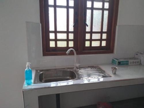 亭可马里JM resort的带窗户的厨房内的盥洗盆