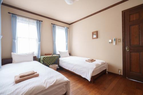 北斗市Lodge Kent的客房设有两张床和窗户。