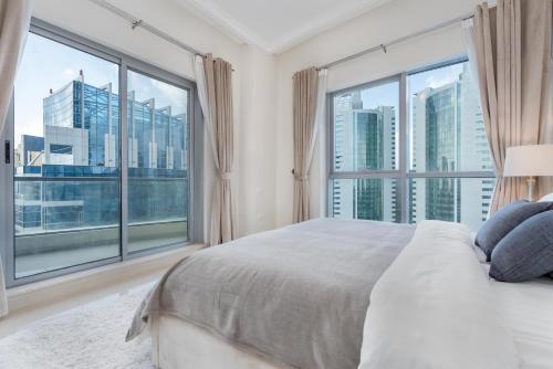 迪拜Perfect 2BD apartment in the heart of Marina - top spot的一间卧室设有一张大床和大窗户