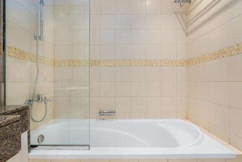 迪拜Perfect 2BD apartment in the heart of Marina - top spot的一间带浴缸和玻璃淋浴的浴室