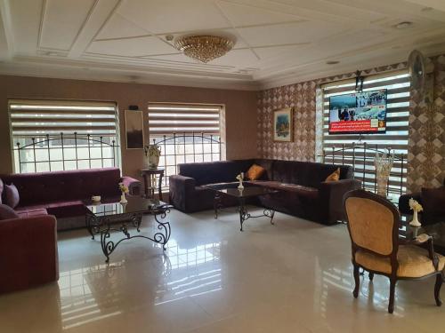安曼阿哈蒂尔酒店的带沙发和桌子的客厅以及窗户。