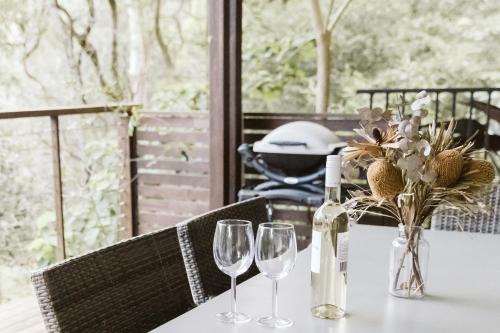 马莱尼"On Burgum Pond" Cottages的一张桌子,上面放着两杯酒和一瓶葡萄酒