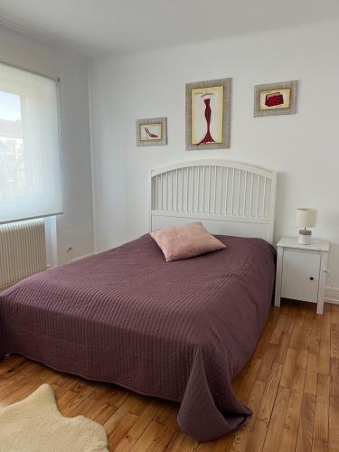 赫伯格Location chez marie的一间卧室配有一张大床和紫色毯子