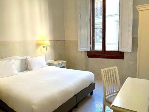 佛罗伦萨杜卡德奥斯塔酒店的一间卧室配有一张床、一张桌子和一个窗户。