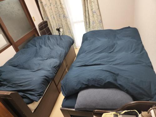 泉佐野MINPAKU-P 民泊p的带窗户的客房内设有两张单人床。