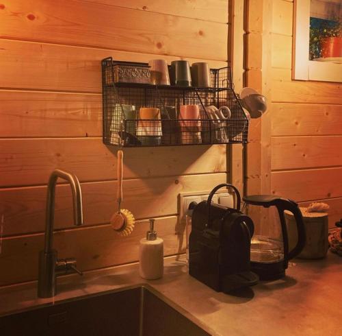海尔德罗普Bed and breakfast de Heg的厨房柜台设有水槽和带杯子的架子