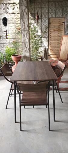 康提Boscage Homestay的一张木桌、两把椅子和长凳