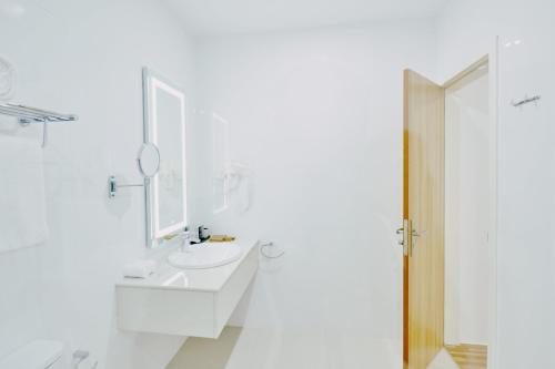 KamadhooAkomadoo Retreat的白色的浴室设有水槽和镜子