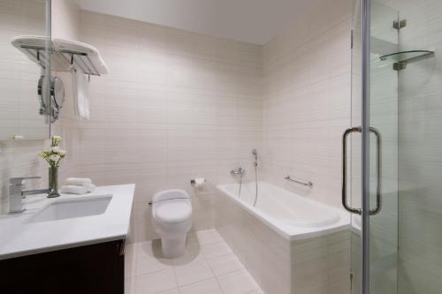 多哈Marriott Executive Apartments City Center Doha的浴室配有卫生间、浴缸和水槽。