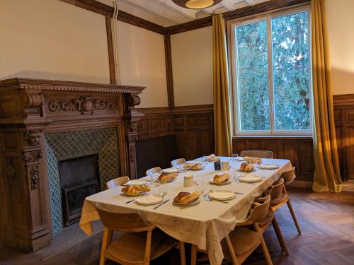 埃特勒塔Villa Eliane - parking privé的一间带桌子和壁炉的用餐室