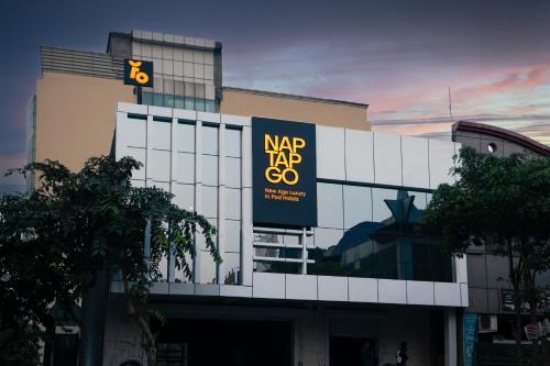 诺伊达NapTapGo - Japanese Premium POD Hotel - Walk to Noida Electronic City Metro! Wifi, Lounge的建筑的侧面有大标志