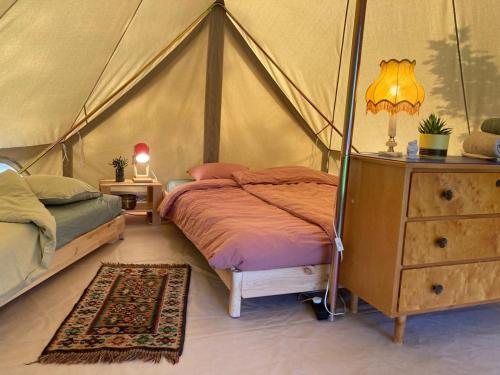 图什比Winter Glamping Tent Hovfjallet Vitsand的帐篷内一间卧室,配有一张床