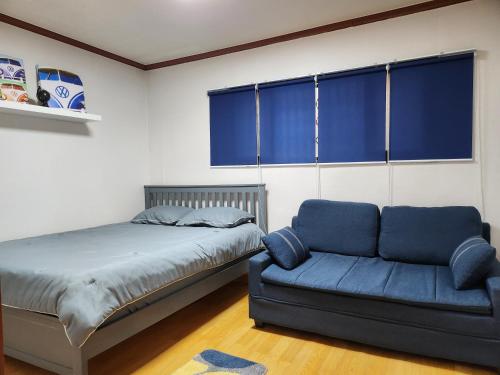 首尔Spacious Master Suite的一间卧室配有一张床和一张沙发