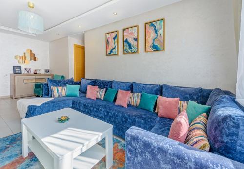 卡萨布兰卡Urban Charm Delight的客厅里配有带色彩缤纷枕头的蓝色沙发