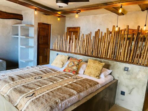 BubaqueCAJOU LODGE的一间卧室配有一张床和一束木棍