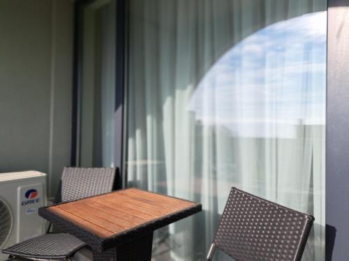 瓦尔纳LUXURY APARTMENT in Mediterranea VARNA Complex, sea view and Infinity pool的阳台上的木桌和椅子