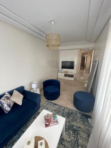 卡萨布兰卡Petit appartement 68m2 quartier Bourgogne的客厅配有蓝色的沙发和蓝色的椅子