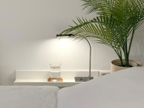 埃森Schöne Ferienwohnung im Zentrum mit Self Check-In und Free Wifi的植物旁边的白色桌子上一杯水