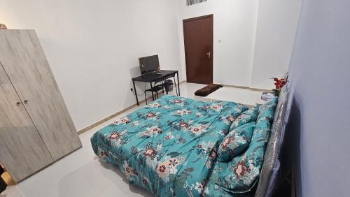 阿布扎比Baith al jannah的一间卧室配有一张床和一张带电脑的书桌
