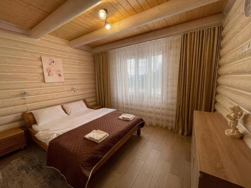 亚布卢尼齐亚Horizon Apartmens的木制客房内的一间卧室,配有一张床