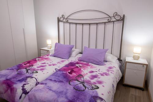 阿里纳加Casa Andrea Doria Arinaga B的一间卧室配有一张带紫色毯子和蝴蝶的床