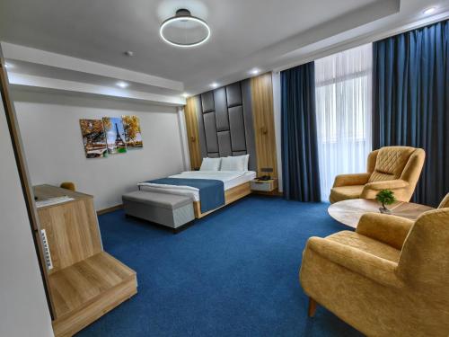 奇姆肯特Shymkent Park Hotel的酒店客房,配有一张床和两把椅子