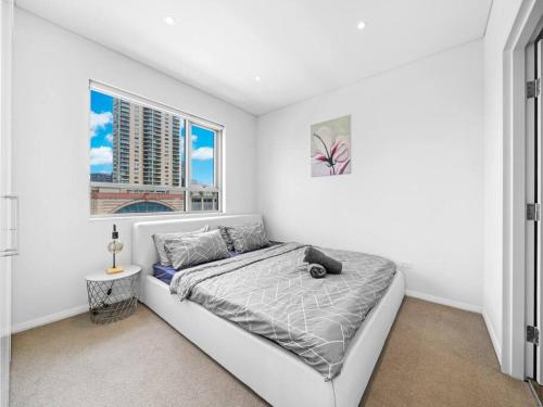 悉尼Lovely Apartment in the heart of Chinatown的白色的卧室设有床和窗户