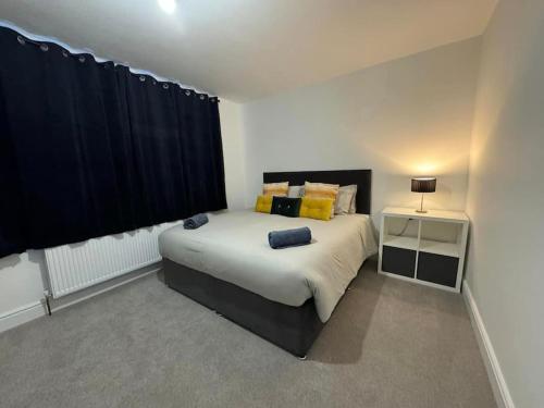 伦敦Modern 5 Bed near ExCel -Big Ben的一间卧室配有一张大床和黑色窗帘