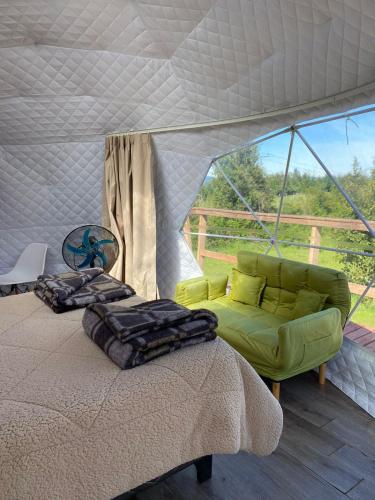 潘吉普伊Milenaria Glamping的一间卧室配有一张床,一张沙发位于帐篷内