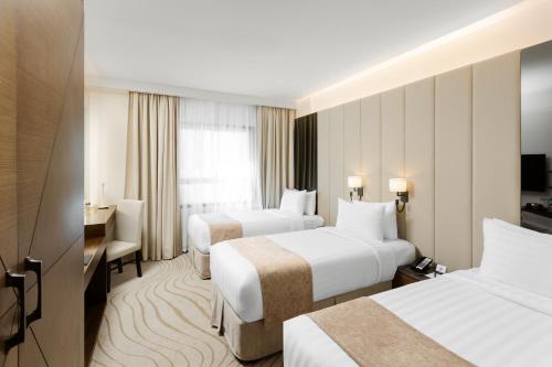 麦地那فندق جايدن-Jayden Hotel的酒店客房配有两张床和一张书桌