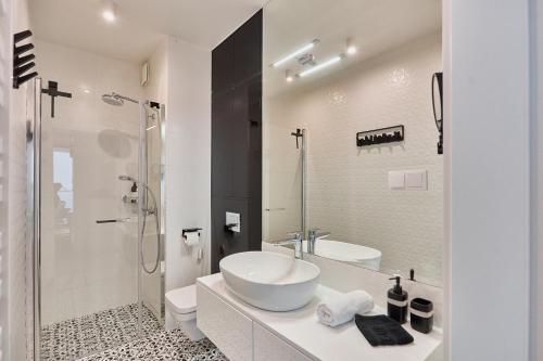 米兹多洛杰Wave Panorama Apartment - Sea View&SPA的白色的浴室设有水槽和淋浴。