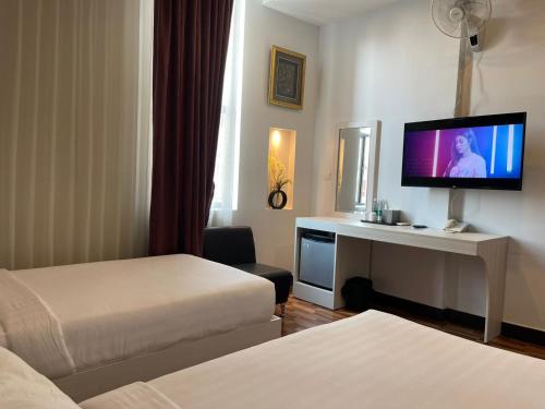 金边DE Hotel的酒店客房设有两张床和一台平面电视。