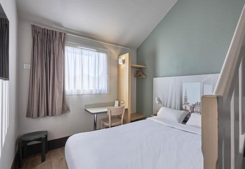 翁弗勒尔B&B HOTEL Honfleur的配有一张床和一张书桌的酒店客房