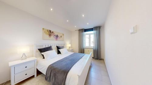 阿尔泽特河畔埃施STAY SMART Luxembourg Esch的白色的卧室设有一张大床和一个窗户