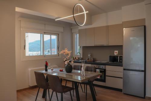 哈尔基斯Elia Luxury Residence的厨房配有桌椅和冰箱。