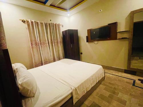 卡拉奇Hotel Bed & Rest Airport的一间卧室配有一张床和一台平面电视