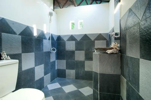 吉利美诺Thank You Bungalow的浴室设有黑色和白色瓷砖淋浴。