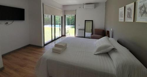 卢汉德库约Los Álamos Vistalba的卧室配有一张白色大床和电视。
