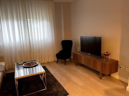 费罗尔Piso en el centro de Ferrol recién reformado.的客厅配有平面电视和椅子。