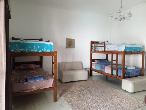 圣克鲁斯Guajira Hostel SCZ的带两张双层床和椅子的房间