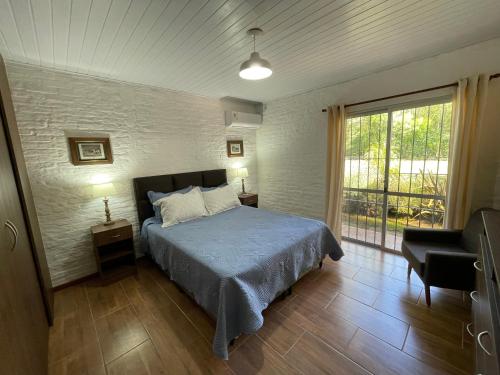 科洛尼亚-德尔萨克拉门托Magnolio的卧室配有床、椅子和窗户。