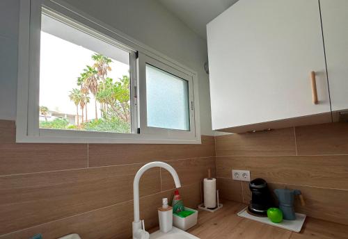 塔瓦伊瓦Modern open-plan studio with terrace and sea view的厨房设有水槽和窗户。