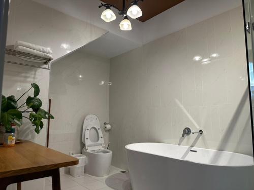 嘉义市上水民宿的白色的浴室设有浴缸和卫生间。