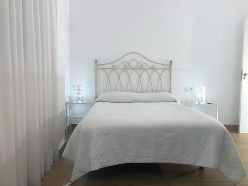 哈恩Centrico alojamiento的白色卧室配有带白色床单的床