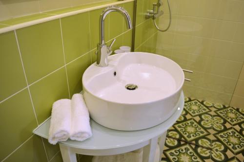 罗德镇艾利普酒店的浴室内的一个白色水槽,上面有毛巾